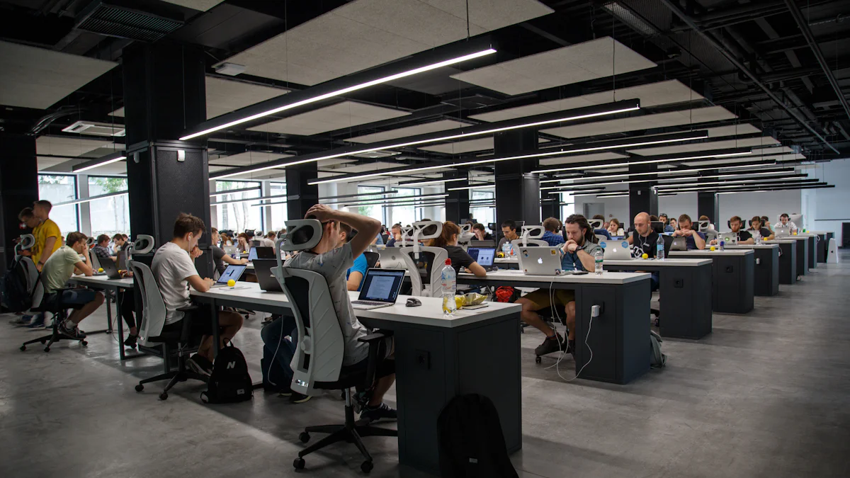 Gran sala de trabajo con filas de escritorios y personas con notebooks